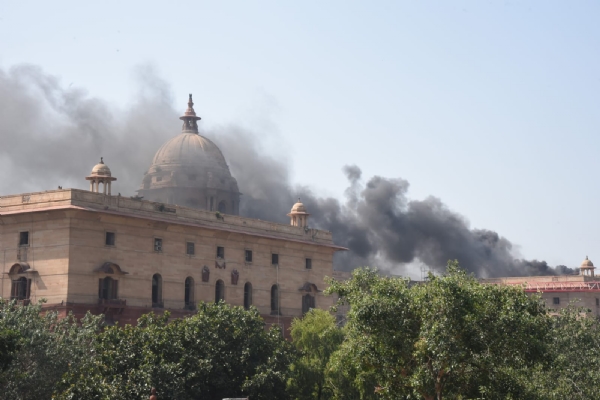 नई दिल्ली में सोमवार को नॉर्थ ब्लॉक की छत पर निर्माण कार्य के दौरान वेल्डिंग से उठे धुएं का दृश्य।